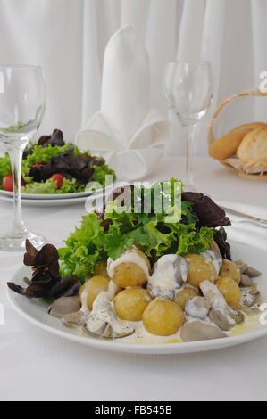 Bratkartoffeln mit Champignons und Rahmsauce in Kopfsalat Blätter Stockfoto