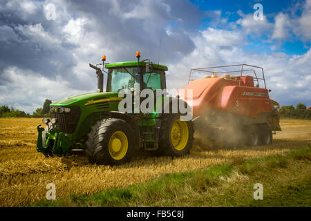 John Deere Traktor und Massey Ferguson Ballenpressen Strohballen Stockfoto