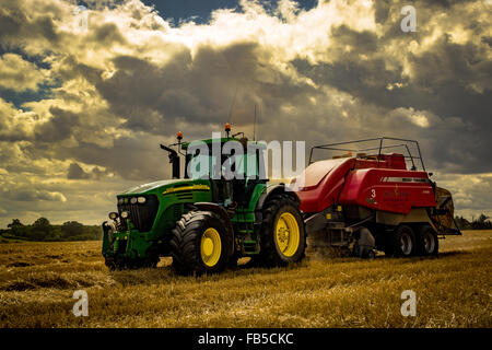 John Deere Traktor und Massey Ferguson Ballenpressen Strohballen Stockfoto