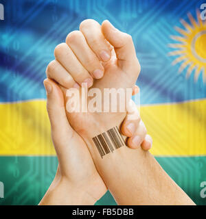 Barcode-ID-Nummer am Handgelenk einer menschlichen und nationale Flagge auf Hintergrund-Serie - Ruanda Stockfoto