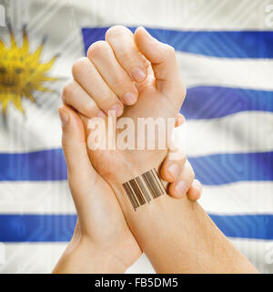 Barcode-ID-Nummer am Handgelenk einer menschlichen und nationale Flagge auf Hintergrund-Serie - Uruguay Stockfoto