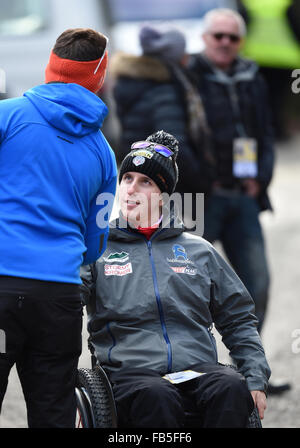 Ehemaliger US-Skispringer Nick Fairall (R) macht seinen Weg über das Basislager der Sportler in seinem Rollstuhl an den Skisprung-Weltcup in Willingen, Deutschland, 10. Januar 2016. Fairall erlitt eine Fraktur, seine Lendenwirbelsäule letztes Jahr bei einem Sturz in der Qualifikation der letzten Veranstaltung der Vierschanzentournee in Bischofshofen, Österreich. Foto: ARNE DEDERT/dpa Stockfoto