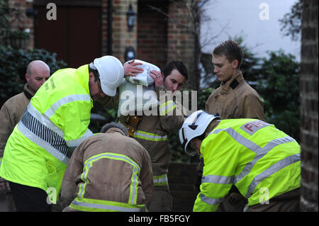 Feuerwehrleute heben und bewegen Sandsäcke, um zu verhindern, dass Häuser aufgrund eines geplatzten Flusses in Arundel, West Sussex, England, überschwemmt werden. Stockfoto