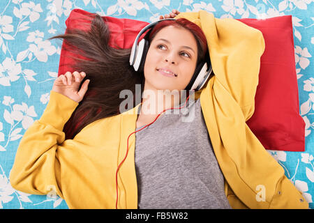 Mein Traum Song. Schöne junge Mädchen im Bett liegen und Musik hören. Stockfoto