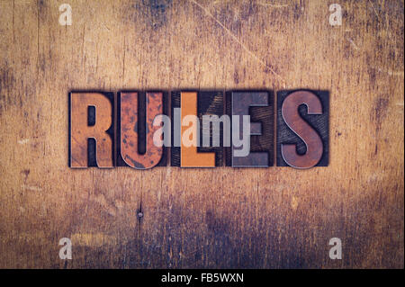 Das Wort "Regeln" in schmutzigen Vintage Buchdruck Typ auf einem alten hölzernen Hintergrund geschrieben. Stockfoto