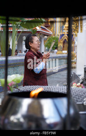 BANGKOK, THAILAND - 26. Oktober 2014: Thai-Frau betet in einem buddhistischen Schrein vor dem Tempel des Smaragd-Buddha. Stockfoto