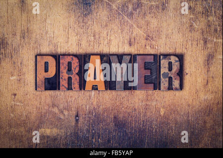 Das Wort "Gebet" in schmutzigen Vintage Buchdruck Typ auf einem alten hölzernen Hintergrund geschrieben. Stockfoto