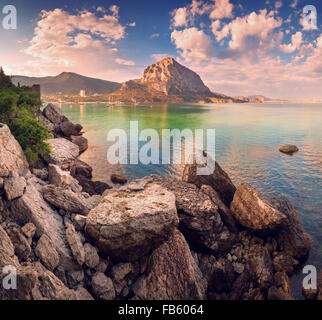 Schönen Sommer Sonnenuntergang am Meer mit Bergen und Steinen auf der Krim Stockfoto