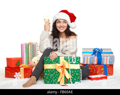 schöne junge Mädchen in Nikolausmütze mit einem Glas Champagner und Geschenk-Boxen Stockfoto