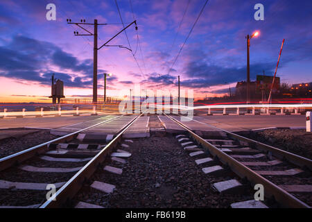 Bahnübergang mit Autolichter in Bewegung in der Nacht. Stockfoto