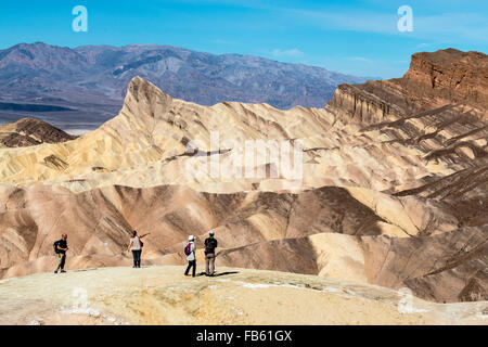 Menschen, die in der Ansicht von Death Valley berühmten Zabriskie Point der umliegenden Wüste Berge. Stockfoto