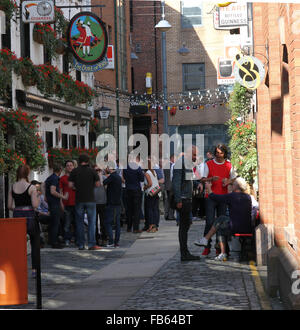 Menschen außerhalb der Duke of York in Handelsgericht Geselligkeit. Handelsgericht ist eine Straße in die blühende Cathedral Quarter Stockfoto