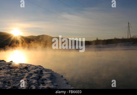 Größere Hinggan-Gebirge, Chinas Provinz Heilongjiang. 10. Januar 2016. Sonnenaufgang über dem Nebel umhüllt Ganhe Fluss in größere Hinggan Berge Region Nordosten Chinas Provinz Heilongjiang, 10. Januar 2016. © Wang Qisheng/Xinhua/Alamy Live-Nachrichten Stockfoto