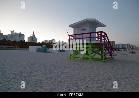 In der Abenddämmerung, ein Rettungsschwimmer station am Sandstrand mit teilweise beleuchteten South Beach Hotels Gebäude im Hintergrund, Miami Beach, Florida. Stockfoto