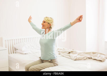 glückliche mittlere gealterte Frau aufstehen Stockfoto