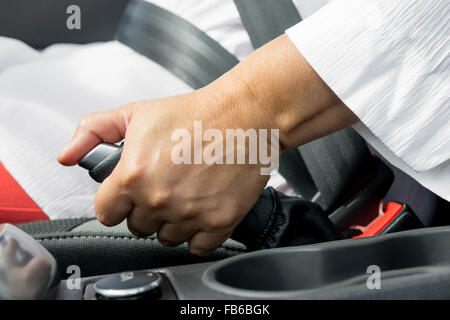 zarte Frauenhand und die Handbremse des Auto-Close-up Stockfoto