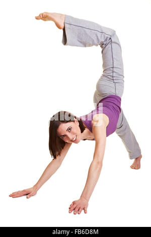 Junge Frau, die isoliert auf weiss versucht einen handstand Stockfoto