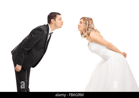 Junge Braut und Bräutigam einander gegenüber stehen und gehen in einen Kuss, isoliert auf weißem Hintergrund Stockfoto