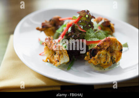 Indische Chicken Pakora und Salat auf einem weißen Teller präsentiert. Stockfoto