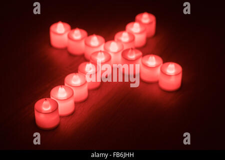 Verschwommenes Bild von Religion Kreuz gemacht durch rote led Kerzen Stockfoto