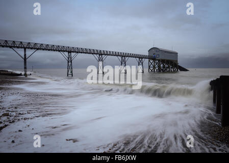 Im Morgengrauen Wellen Pause auf dem Strand vor dem Hotel der RNLI Lifeboat station in Selsey, West Sussex, England. Stockfoto