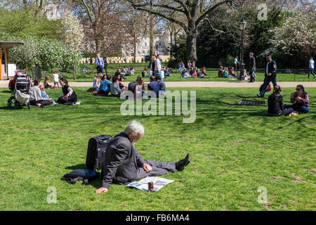 St James' Park, London - älterer Mann Papier liest und genießt die frische Luft und schönem Wetter in der warmen Frühlingssonne Stockfoto