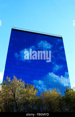 Bürohochhaus mit Reflexion des Himmels und der Wolken an Fassade. Stockfoto