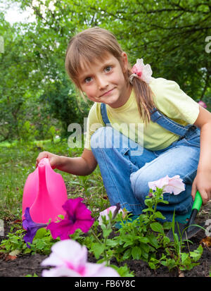 kleines Mädchen in die Federarbeit helfen im Garten Stockfoto