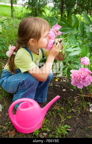 kleines Mädchen in die Federarbeit helfen im Garten Stockfoto