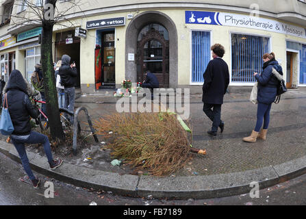 Passanten schauen Blumen und Kerzen, die um ein Foto von David Bowie vor ehemalige Residenz des Sängers an Hauptstrasse 155 in Berlin, Deutschland, 11 Januar 2016 gelegt wurde. Eine Karte, die zwischen den Blumen platziert wurde liest "Für David, Thank You for the Music!". Bowie starb am 10. Januar 2016 an Krebs. Foto: Roland Popp/Dpa - NO-Draht-Dienst- Stockfoto