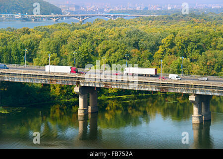 LKW auf einer Brücke über den Fluss in der Stadt. Kiew, Ukraine Stockfoto