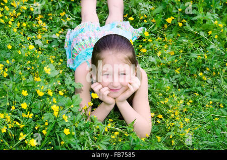 Das Mädchen liegt auf einer Lichtung mit Blumen Stockfoto