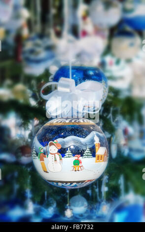 Bunten blauen Weihnachtskugel dekoriert mit einem Schneemann in eine Schneelandschaft Stockfoto