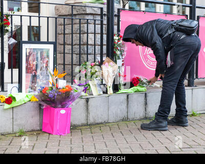 Beckenham, Süd-London, 11. Januar 2016. Ein Mitglied der Öffentlichkeit regelt die Blumen an die ehemaligen drei Tuns Pub (heute ein Restaurant), wo David Bowie startete seine Karriere mit häufigen Sonntag Auftritte und gründete einen folk Club, später in der Arts Lab Musiker David Bowie zu entwickeln starb am 10. Januar, im Alter von 69 Jahren. Bildnachweis: Imageplotter und Sport/Alamy Live Nachrichten Stockfoto