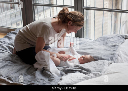 Mutter mit Babymädchen im Schlafzimmer spielen Stockfoto