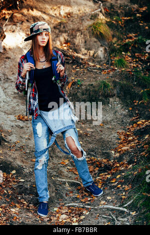 In voller Länge Portrait Mode jungen Frau mit zerrissenen Jeans im Wald Stockfoto