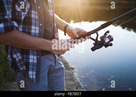 Mittelteil des Menschen Angeln am See im Wald Stockfoto