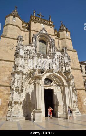 Einige Menschen gehen aus dem Kloster des Heiligen Kreuzes, am besten bekannt als Kirche Igreja in Coimbra, Portugal. Stockfoto