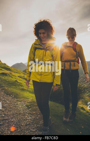 Freundinnen gehen auf Berg gegen Himmel bei Sonnenuntergang Stockfoto