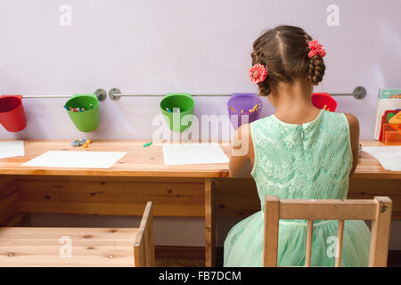 Rückansicht des Mädchen zeichnen am Schreibtisch im Klassenzimmer Stockfoto