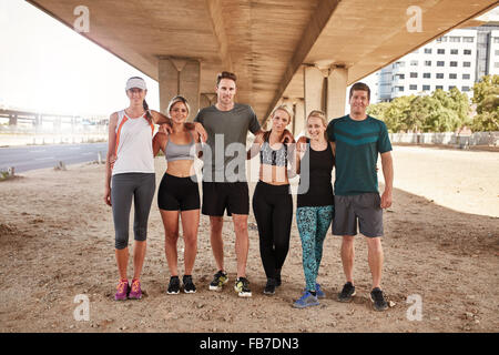 Porträt des laufenden Club Gruppe zusammenstehen und posiert für die Kamera. Gesunde junge Männer und Frauen im freien training. Stockfoto