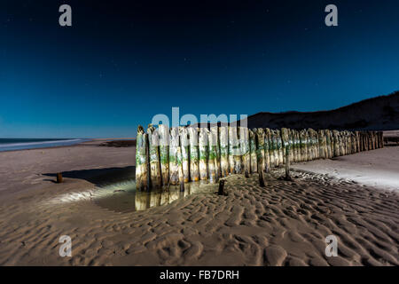 Buhne Beiträge am Strand in der Abenddämmerung Stockfoto