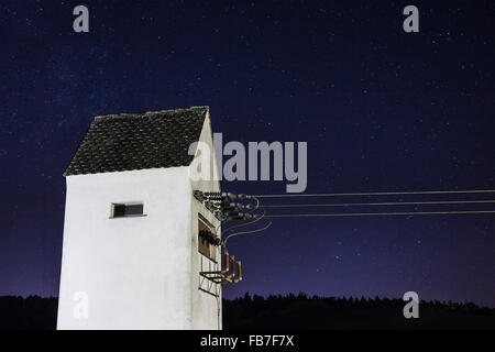 Niedrigen Winkel Blick auf Power Kabel, Gebäude gegen Sternenhimmel Stockfoto