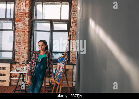 Porträt von zuversichtlich Malerin Standby Leinwand im studio Stockfoto