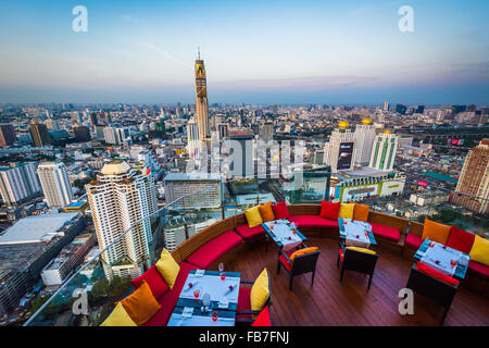 Blick auf moderne Wolkenkratzer in Siam bei Sonnenuntergang vom Restaurant auf der Dachterrasse in Bangkok, Thailand. Stockfoto