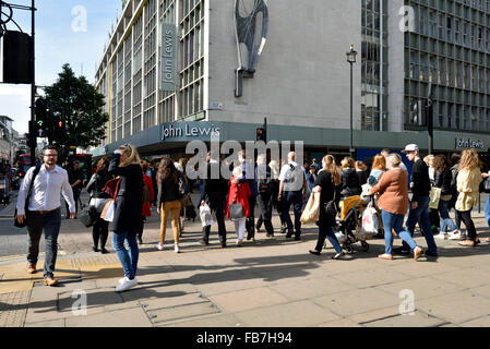 Menschen, die auf die Straße warten, gegenüber der John Lewis Oxford Street, Central London England Großbritannien Stockfoto