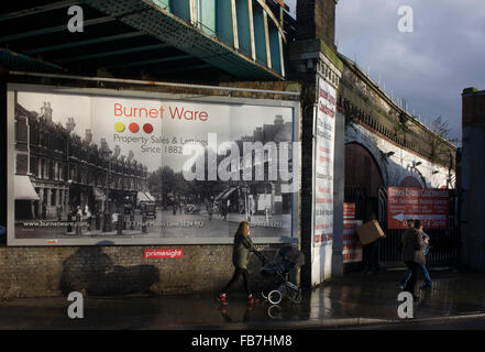 Immobilienmakler Plakatwand zeigt alte Straßenbild unter Eisenbahnbrücke in Herne Hill, South London SE24. Stockfoto