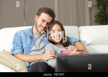 Glückliches Paar einen Film im Fernsehen sitzt auf einer Couch zu Hause Stockfoto