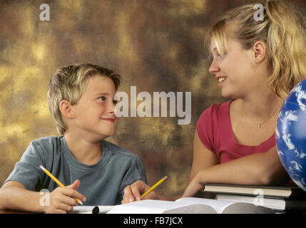 ältere Schwester helfen jüngeren Bruder Studie Stockfoto