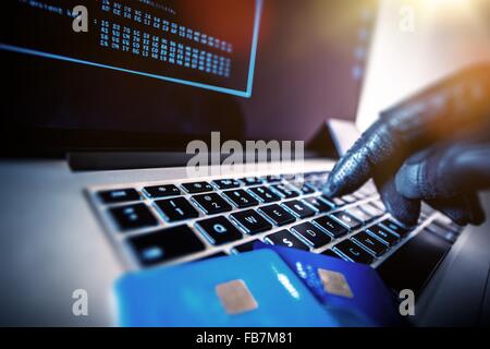 Kreditkarten-Diebstahl-Konzept. Hacker mit Kreditkarten auf seinem Laptop mit ihnen für nicht autorisierte einkaufen. Nicht autorisierte Zahlungen Stockfoto